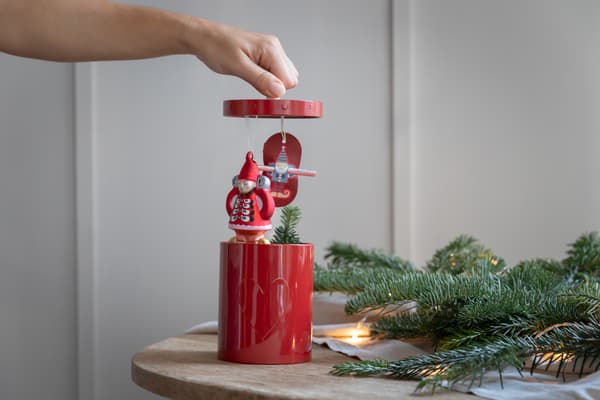 Eine Person öffnet eine rote selbstgemachte Geschenkdose.