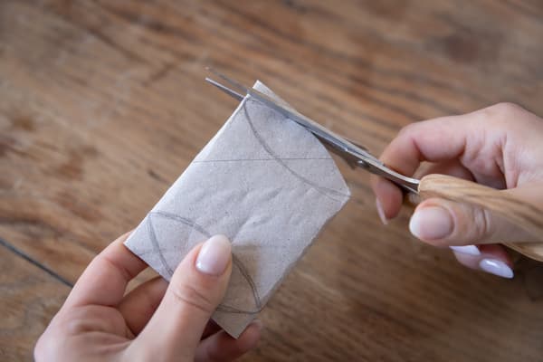Eine Person schneidet ein Stück Papier ab.