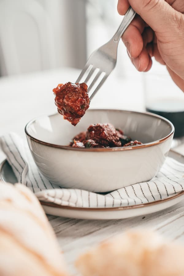 Eine Person sticht mit einer Gabel in PLANTBULLAR Albóndigas.