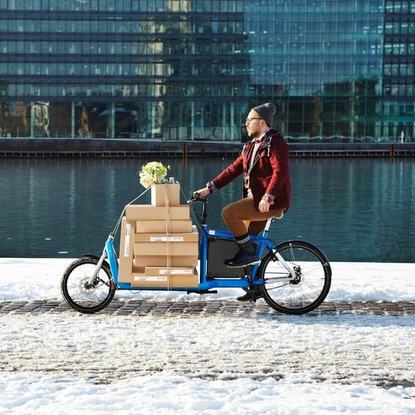 Eine Person transportiert IKEA Pakete mit Hilfe eines E-Lastenrads.