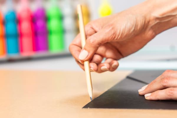 Eine Person zieht eine Linie nach mit einem Stift.