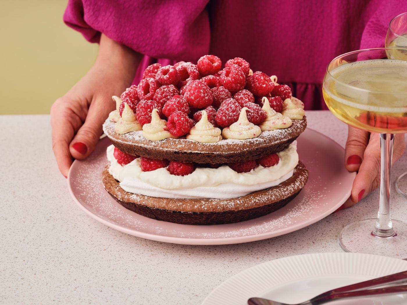 Eine Torte aus Waffeln, Sahne und Himbeeren.