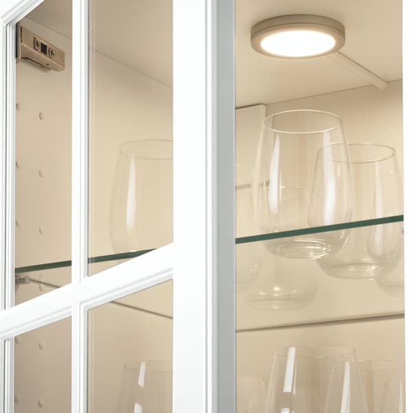 eine weiße, beleuchtete Vitrine mit Gläsern.