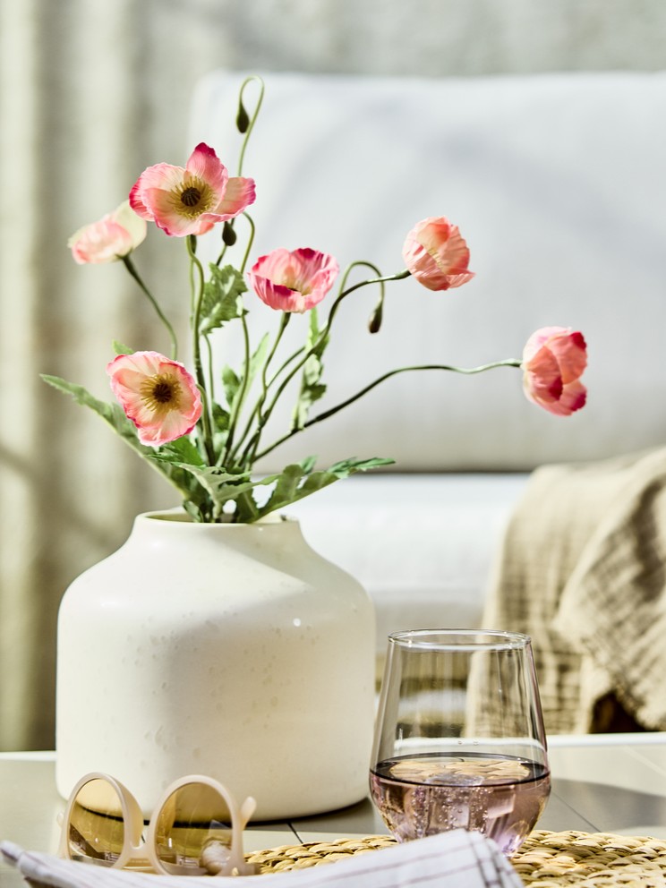 Eine weiße Vase mit SMYCKA Kunstblumen.