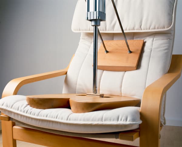 Ejemplo de como funcionan los laboratorios de IKEA. Una silla de madera con un cojín blanco y se preba con planchas de madera la resistencia de la tela y el algodón, para que sea un producto cómodo y cumpla su función con seguridad.