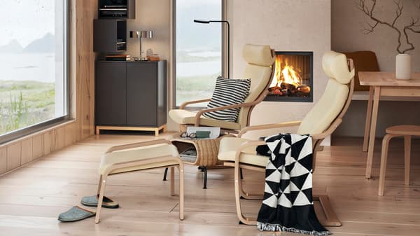EKET cabinet in dark grey with doors that feature integrated push-openers, in a living room with armchairs and two windows.