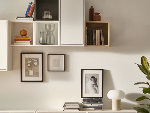 EKHET wall-mounted shelving on wall with framed pictures.