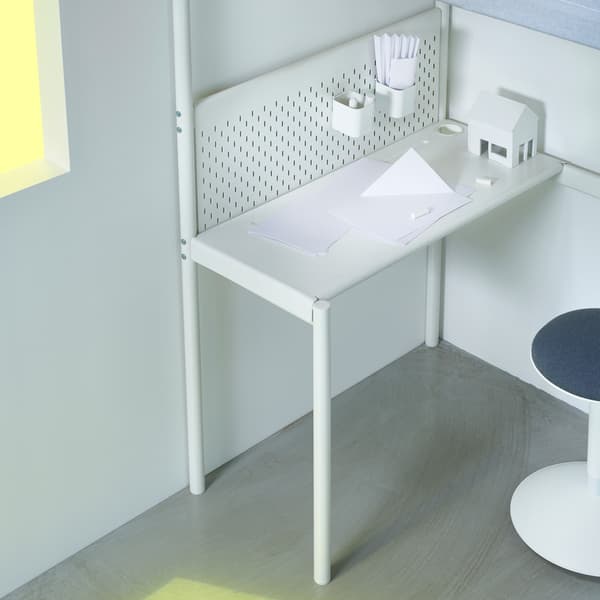El escritorio opcional situado debajo de la cama alta VITVAL, junto con un tablero perforado y accesorios para escritorio.