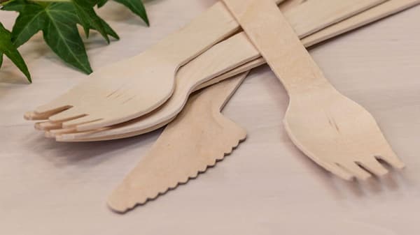 Eldobható IKEA fa villa és kés hever egy fa padon.