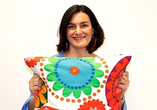 Elena Gasco of IKEA holding a cushion from the ÅTERSTÄLLA collection