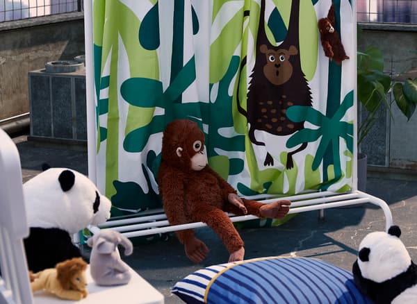 Elfüggönyözött színpad, textília lóg egy ruhaállványon, amit DJUNGELSKOG puha játékok vesznek körül.