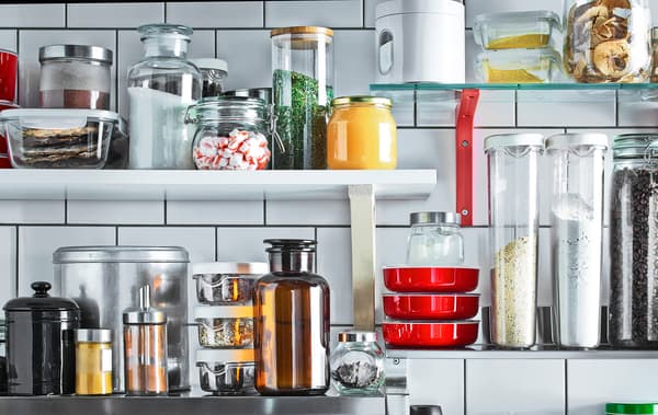 Els prestatges de paret muntats sobre les rajoles blanques emmagatzemen en pots i envasos els ingredients que més s'utilitzen en aquesta cuina.