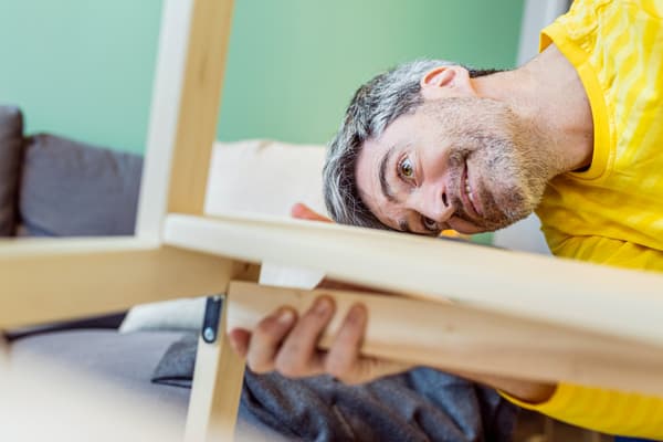 Empleat d’IKEA muntant un moble de fusta.