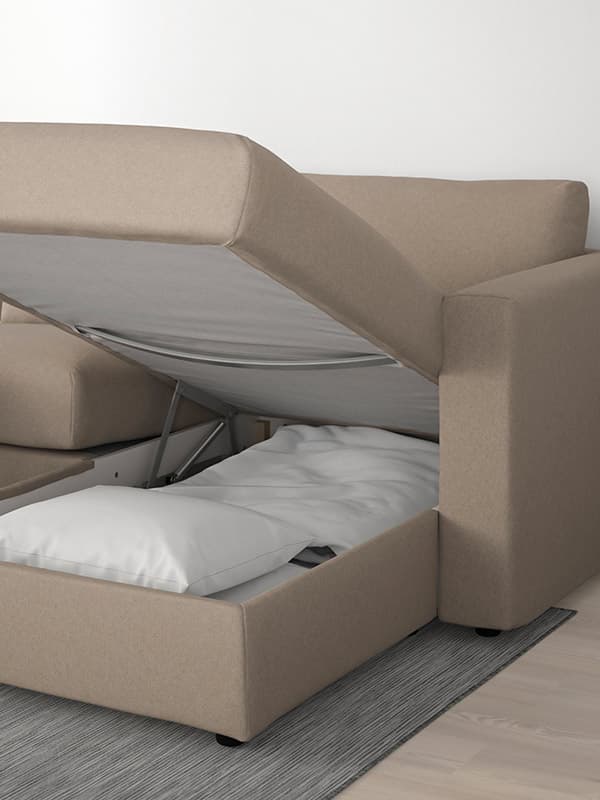En beige VIMLE sovesofa står åben så man kan se opbevaringsplads til sengetøj.