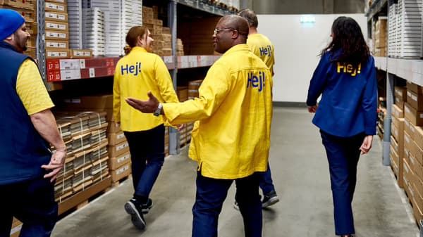 En blandad grupp av IKEA personal som går igenom tag-själv lagret på ett IKEA varuhus.
