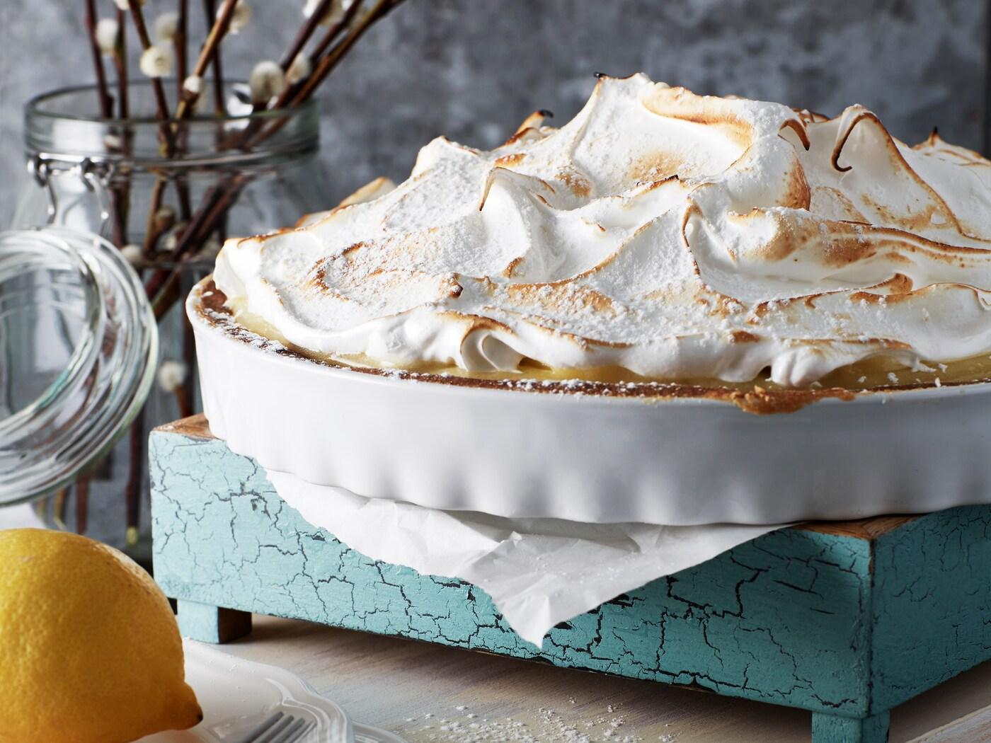 En citronmarängpaj står på ett blått underlägg.