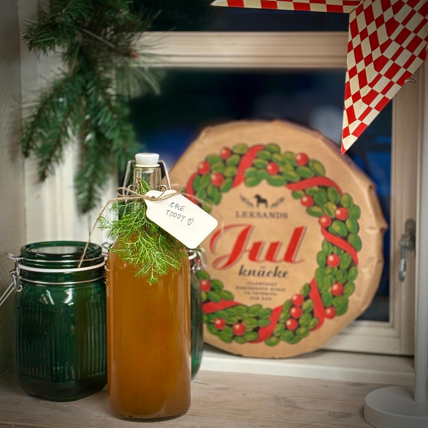 En flaske med hjemmelavet æbletoddy, pyntet med en kvist.