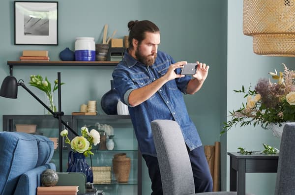 En fyr som tar bildet av gamle IKEA-møbler.