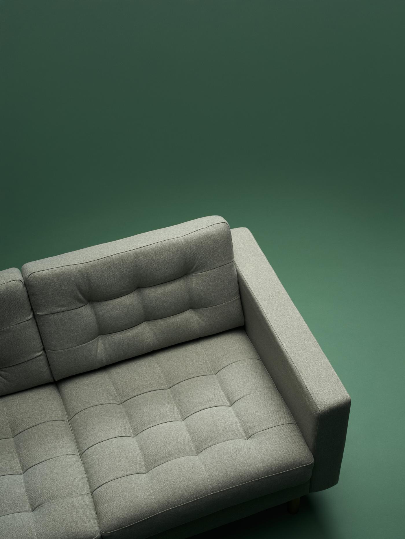En grå LANDSKRONA sofa på en grøn baggrund