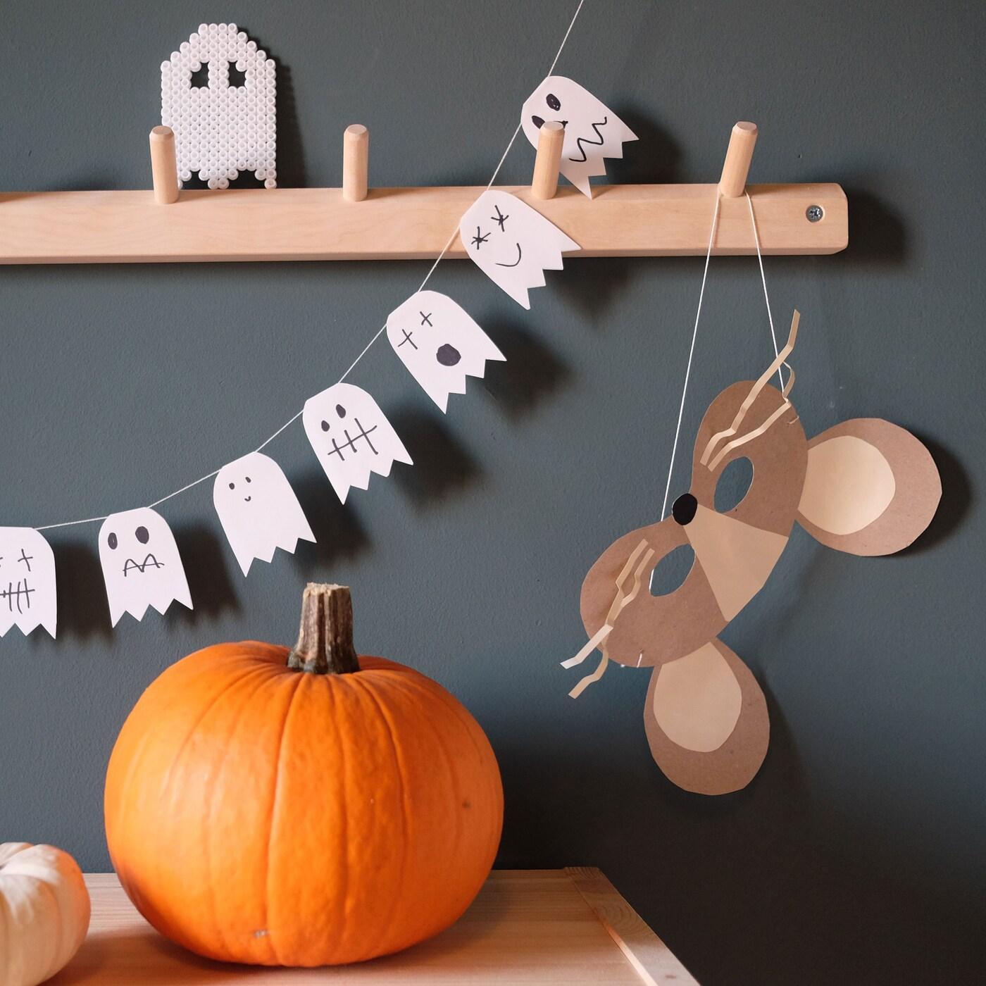 En halloweenpumpa framför en grå vägg.