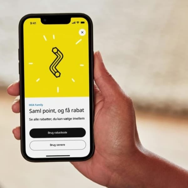 En hånd holder en smart phone, der er åbnet i IKEA appen