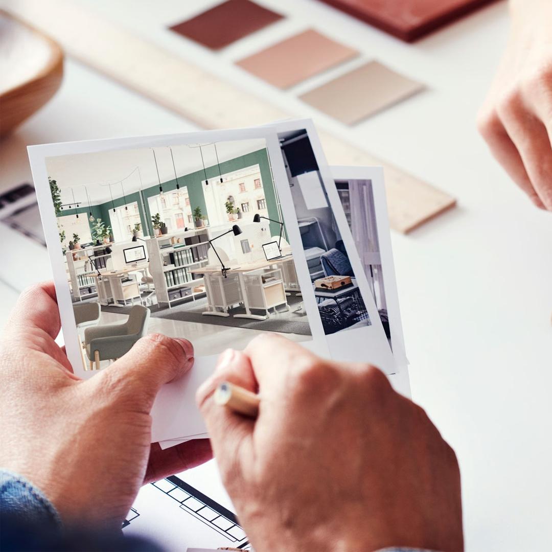 En hånd sidder med et fotografi af en stue