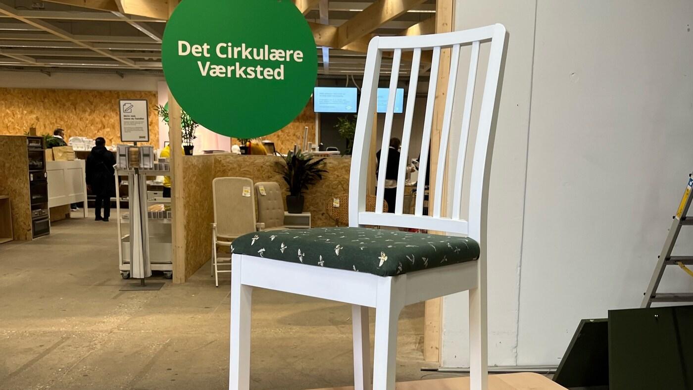 En hvid spisebordsstol står foran Cirkulär i et IKEA varehus.