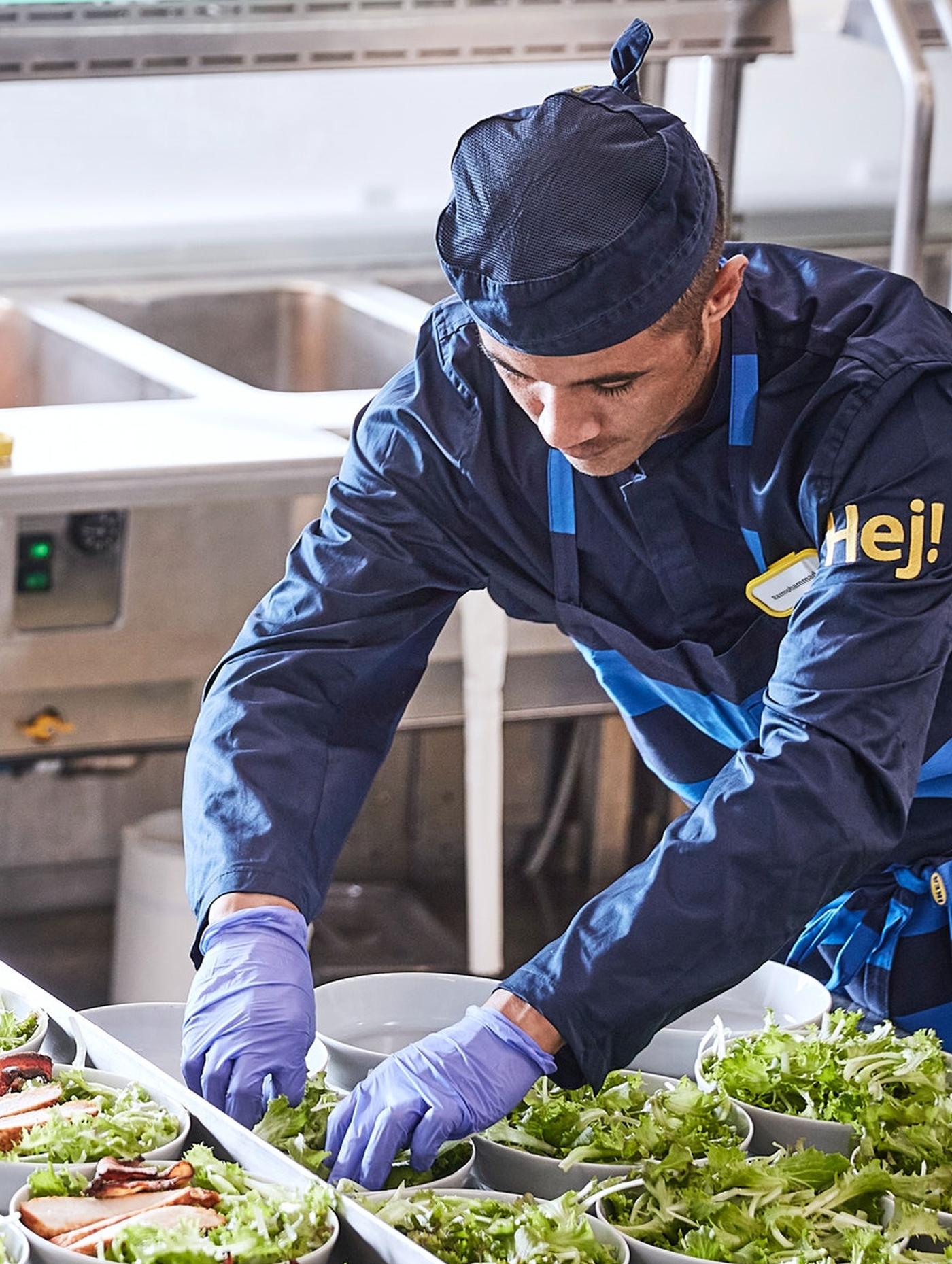 En IKEA ansatt i restauranten står og tilbereder smørbrød.