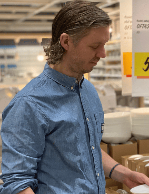 En IKEA medarbatare på varuhuset som kollar på en produkt.