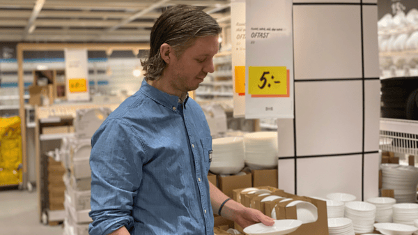 En IKEA medarbatare på varuhuset som kollar på en produkt.