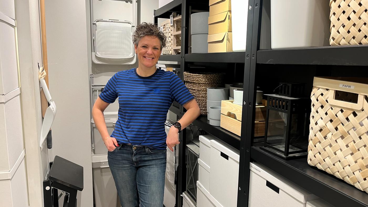 En IKEA medarbejder står i et velorganiseret kælderum eller opbevaringsrum og er klar til liveshopping.