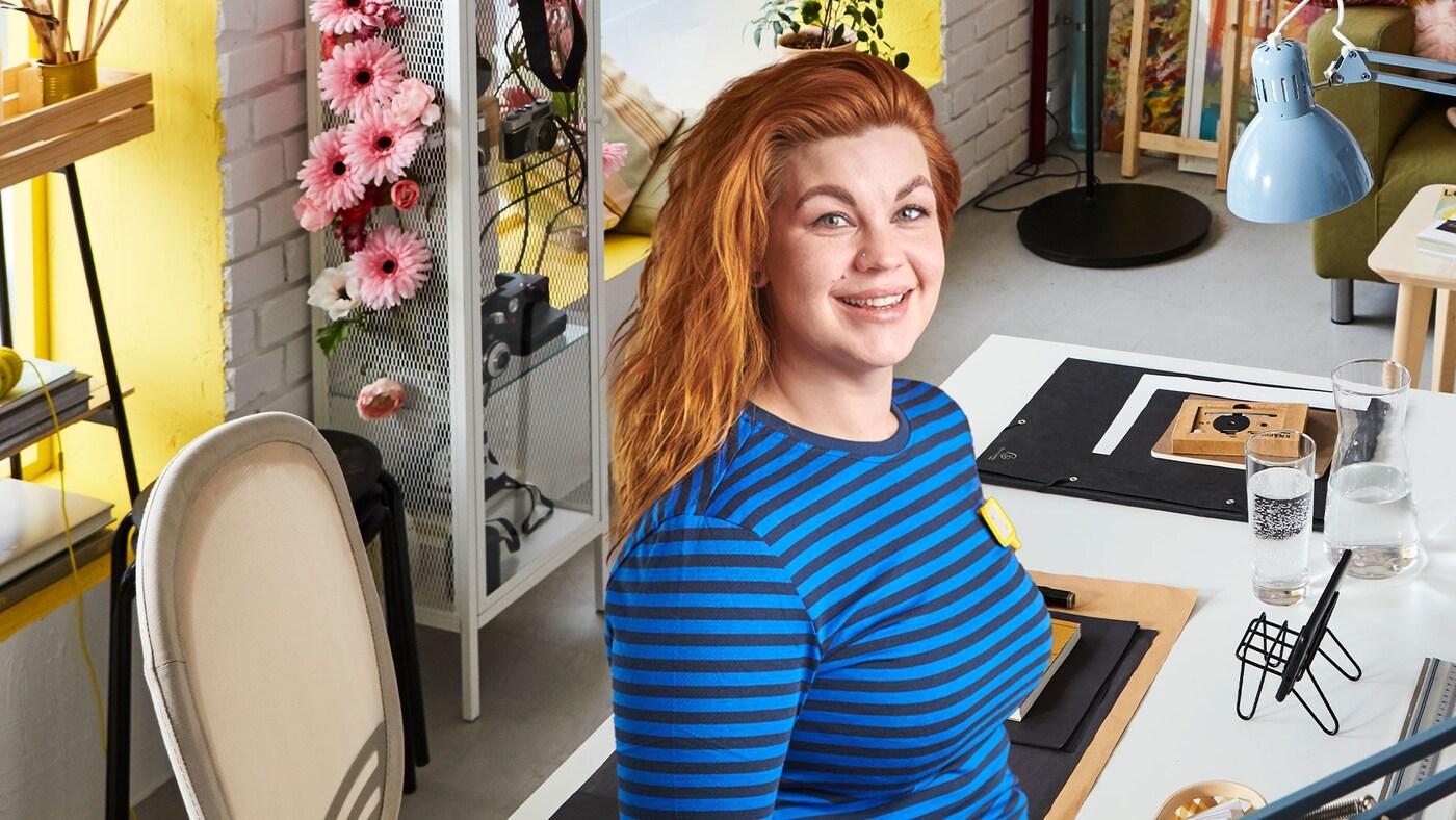 En IKEA medarbetare framför ett skrivbord.