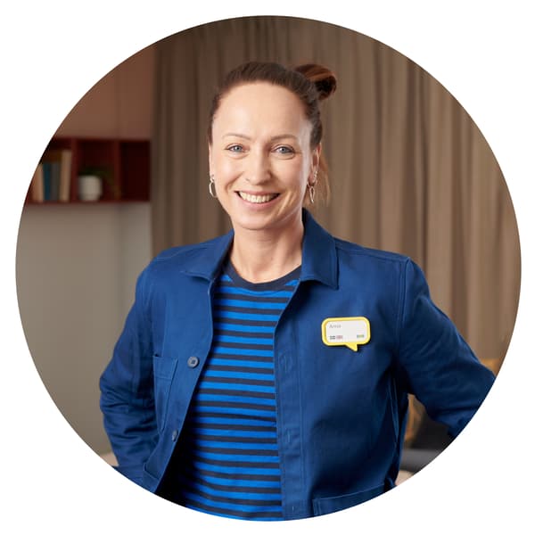 En IKEA medarbetare i blå arbetskläder. 