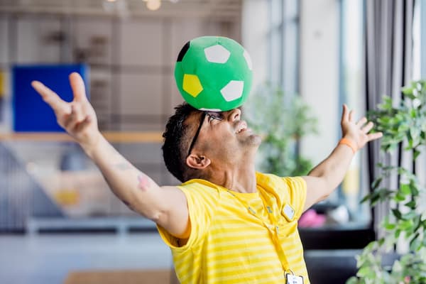 En IKEA medarbetare som balanserar en boll på huvudet.