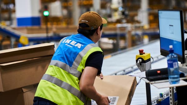 En IKEA medarbetare som jobbar på ett lager med postpaket.