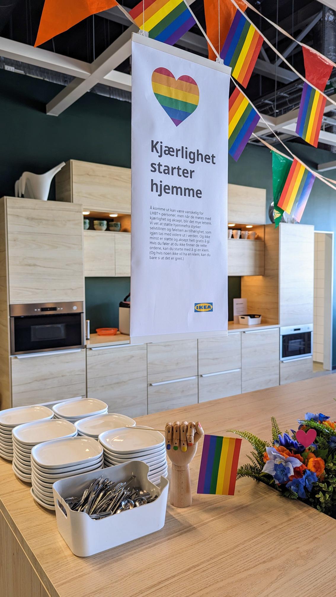 En IKEA utstilling med PRIDE banner og et skilt som står Kjærlighet starter hjemme.