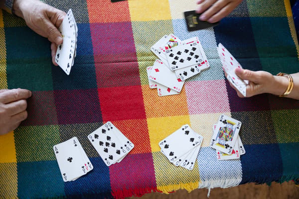 En kortlek ligger utspridd på ett bord. En man och en kvina spelar kort. 
