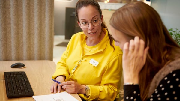 En kund och en försäljare sitter vid ett bord.