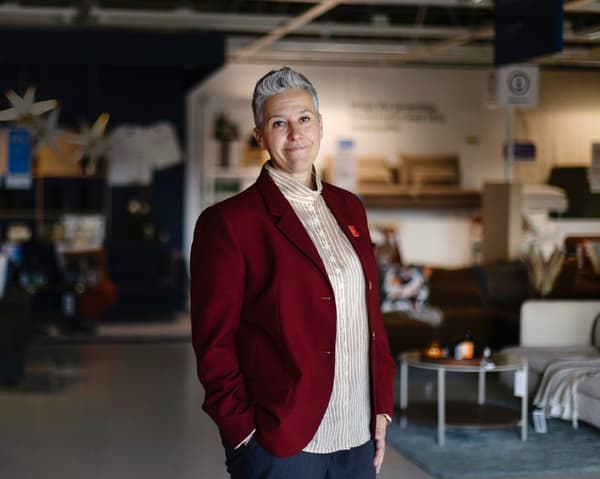 En kvinna med röd kavaj står i ett IKEA-varuhus. 