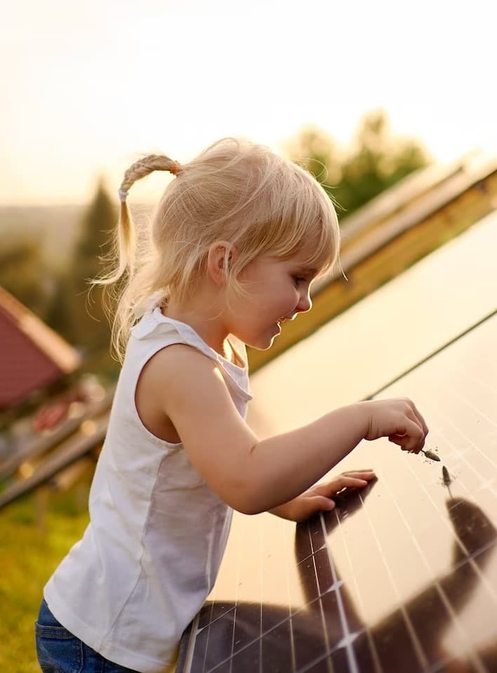 En liten flicka som leker med en solpanell.