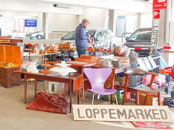 En loppemarkedsstand med stole, borde, lamper og nips. 