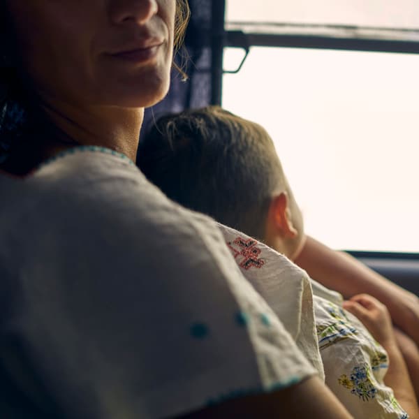 En mamma som håller sitt barn på bussen.