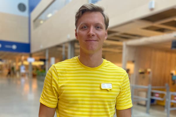 En man i en gul IKEA-tröja står i ett IKEA-varuhus.