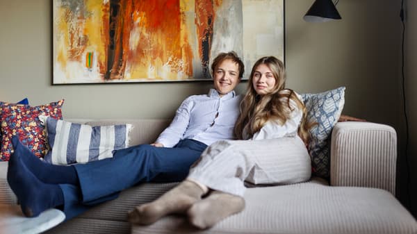 En man och en kvinna sitter i en beige soffa.