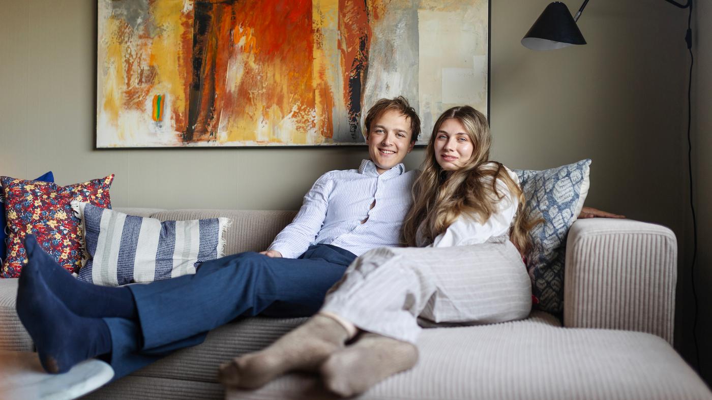 En man och en kvinna sitter i en beige soffa.
