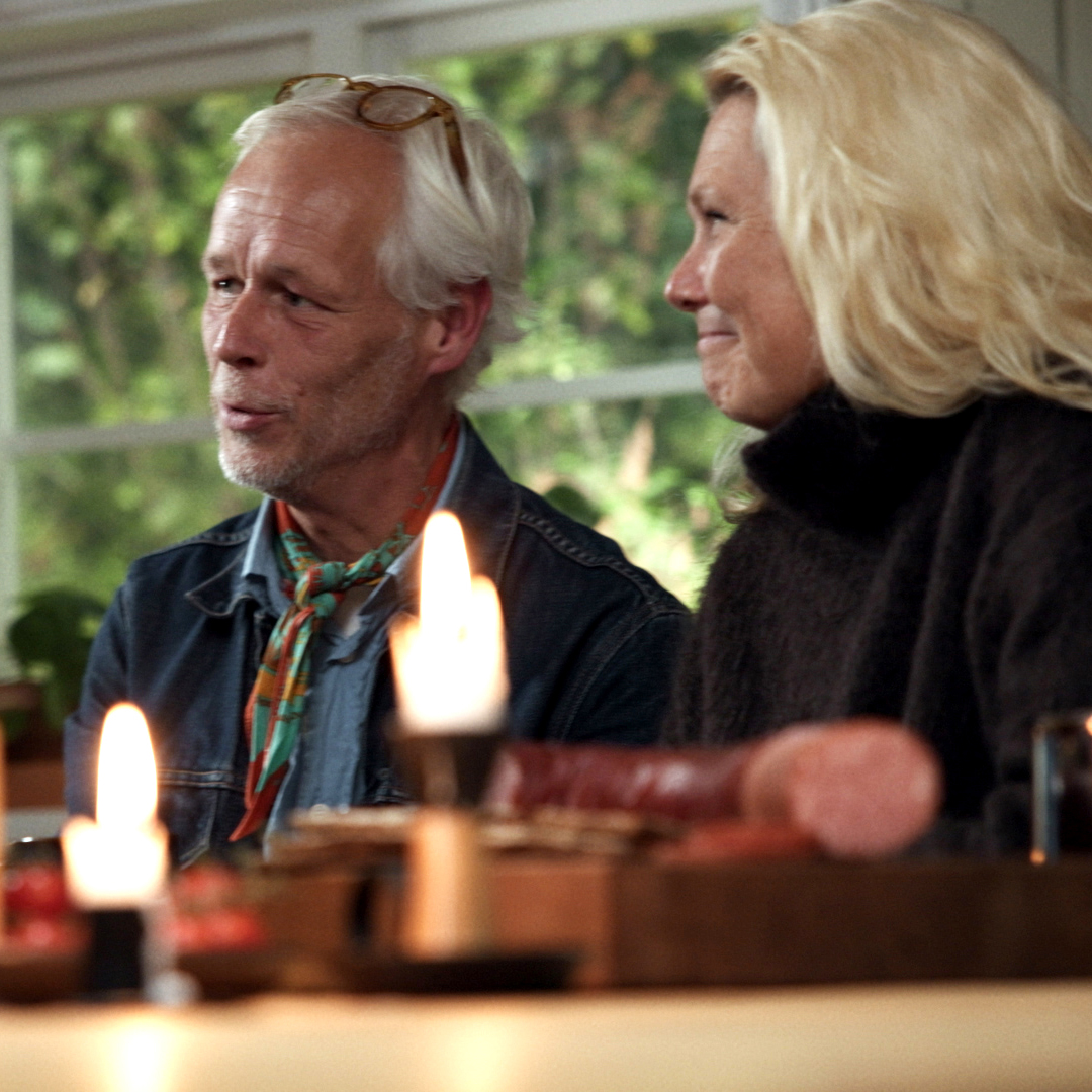 En man och en kvinna sitter runt ett bord och samtalar.