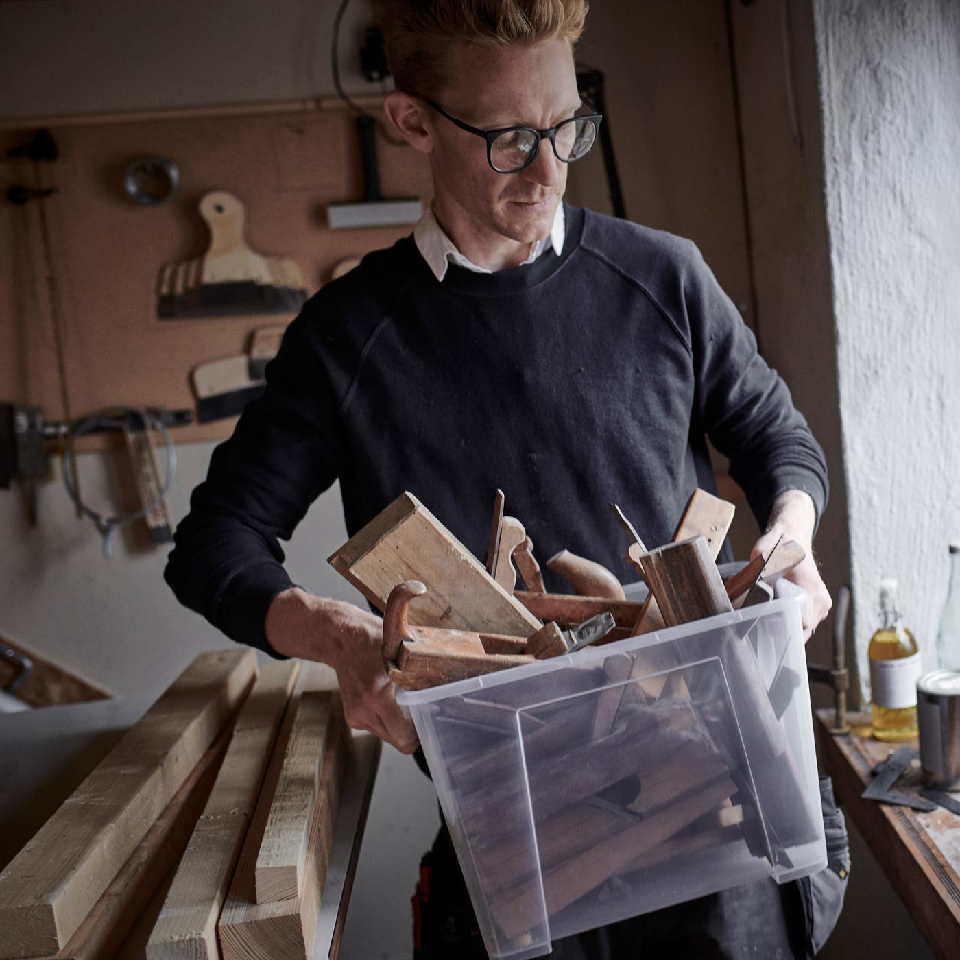 En mand bærer på en SAMLA kasse med verktøy i.