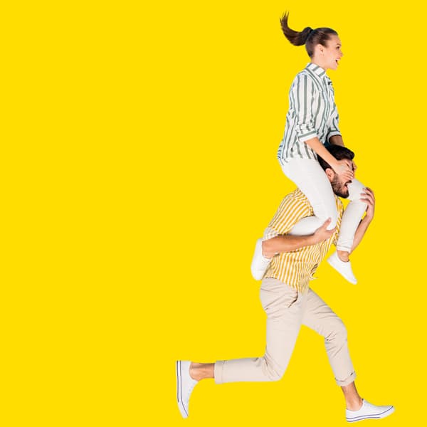 En mand løber med en kvinde siddende på skulderen