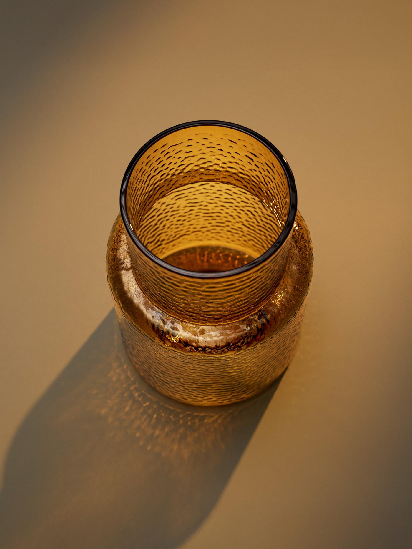 En mundblæst orangebrund KONSTFULL vase på orange baggrund