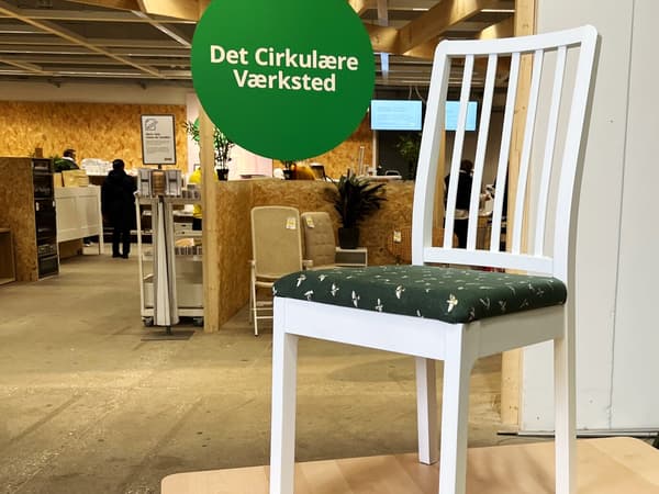 En ompolstret stol står på et bord foran Cirkulär i et IKEA varehus.